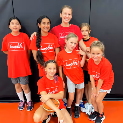 Youth basketball players in action on an indoor court with hooplife branding on the walls.